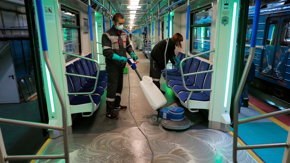 Menschen putzen U-Bahn.