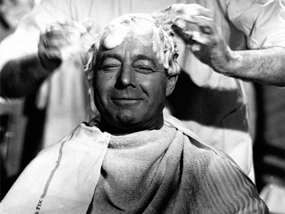 Ein Mann lässt sich beim Coiffeur die Haare waschen.