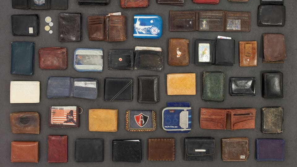 In Reihen arrangierte Brieftaschen und Portemonnaies unterschiedlicher Farben, Grössen und Materialien.