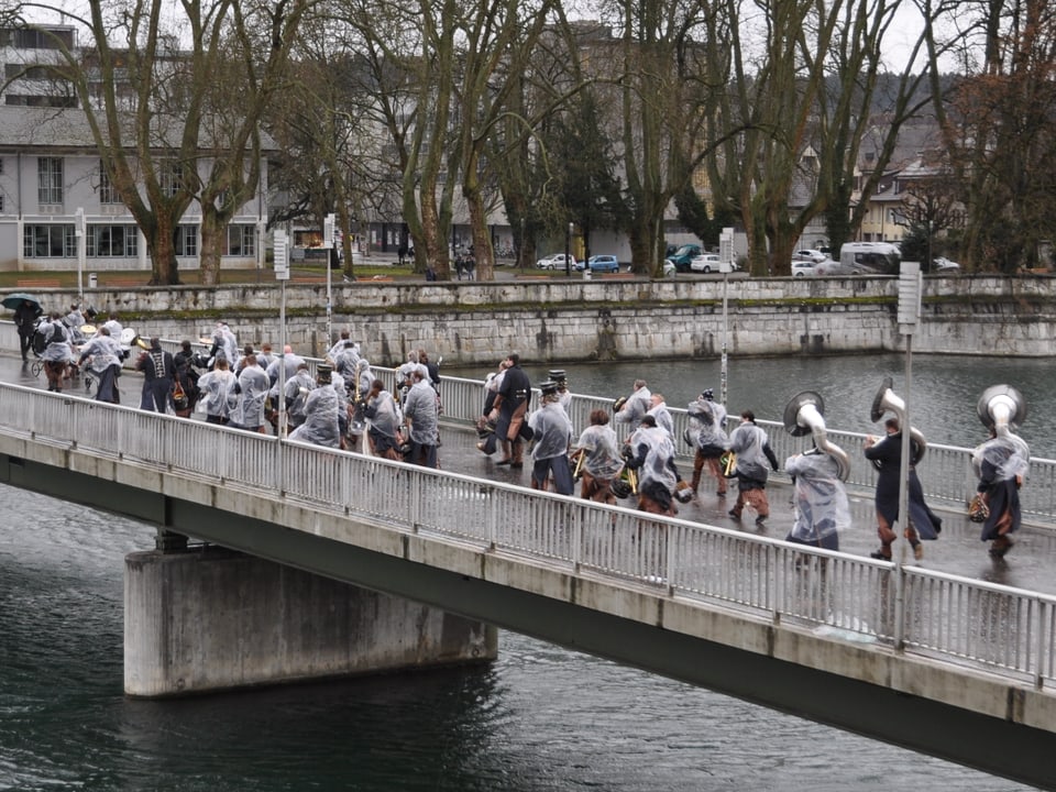 Menschen Regenschützen auf einer Brücke.