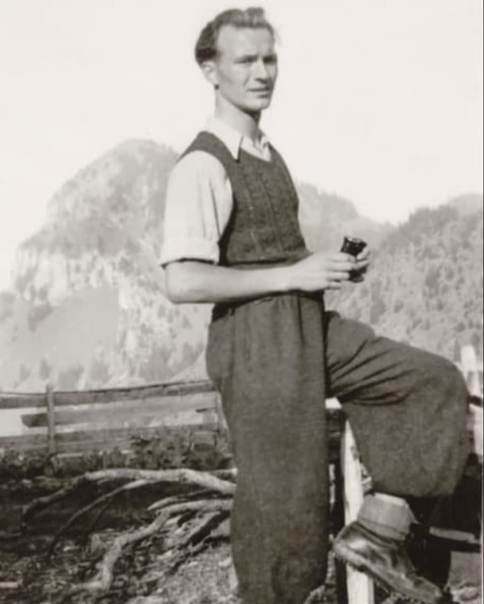 Archivfoto eines Mannes mittleren Alters mit Seitenscheitel. Er steht in Pollunder und Pumphose in bergiger Umgebung