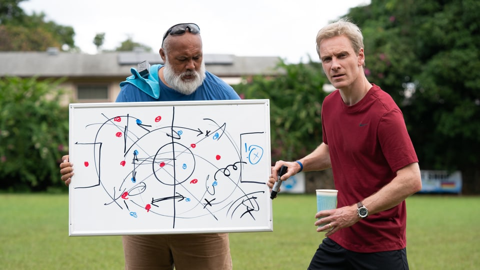 Michael Fassbender versucht als Trainer von Amerikanisch-Samoa mit Hilfe einer Tafel, seine Fussballtaktik zu erläutern.