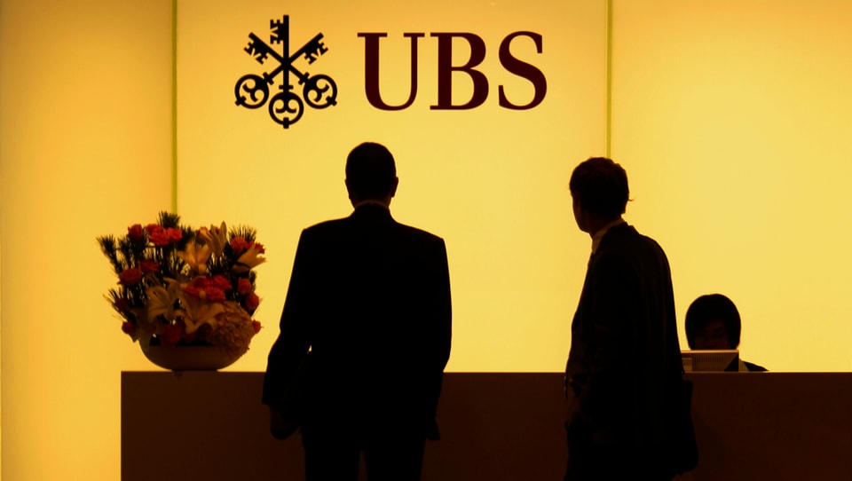 Zwei Männer stehen am Emfpang einer UBS-Filiale in Hongkong. 