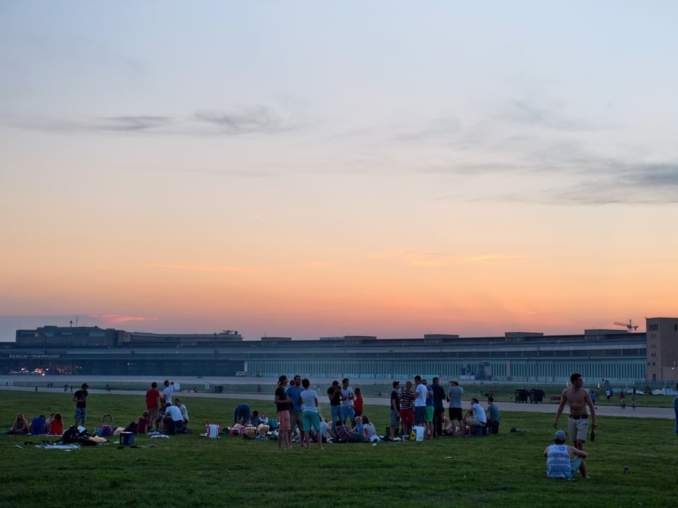 Die Sonne ist untergegangen auf dem Tempelhof, Dutzende Menschen geniessen die Stimmung.