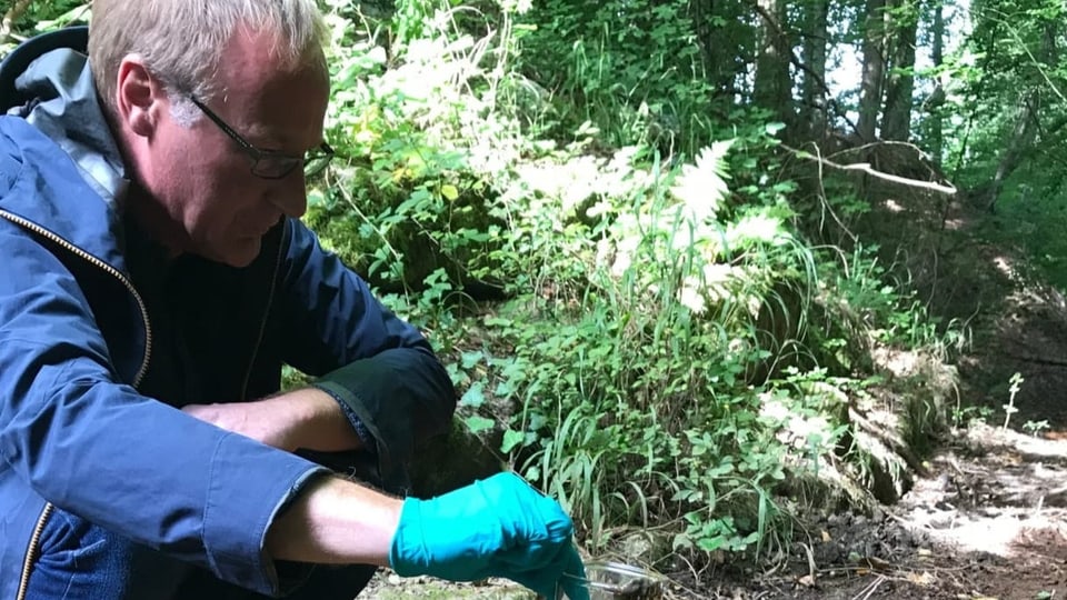 Forter hält Wasserprobe in der Hand