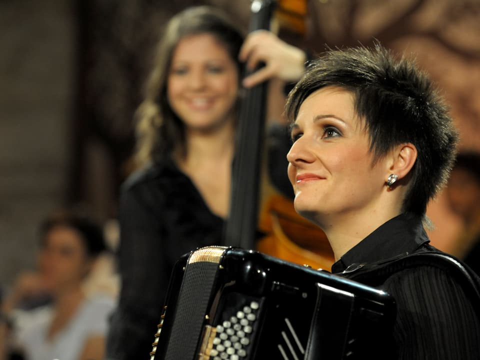 Sonja Schälin von DAAMÄTUUR, im Hintergrund Martina Rohrer am Bass.