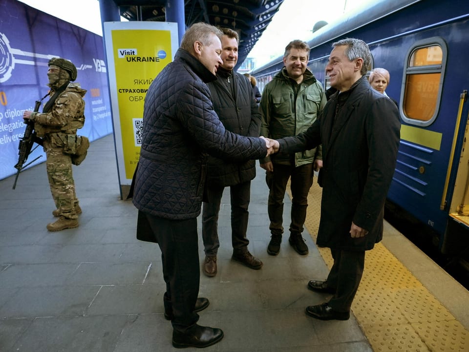 Ignazio Cassis steht auf einem Bahnhofperron und schüttelt die Hand des ukrainischen Vize-Aussenministers.