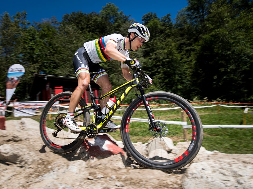 Nino Schurter tritt im Weltmeister-Trikot in die Pedalen seines Mountainbikes.