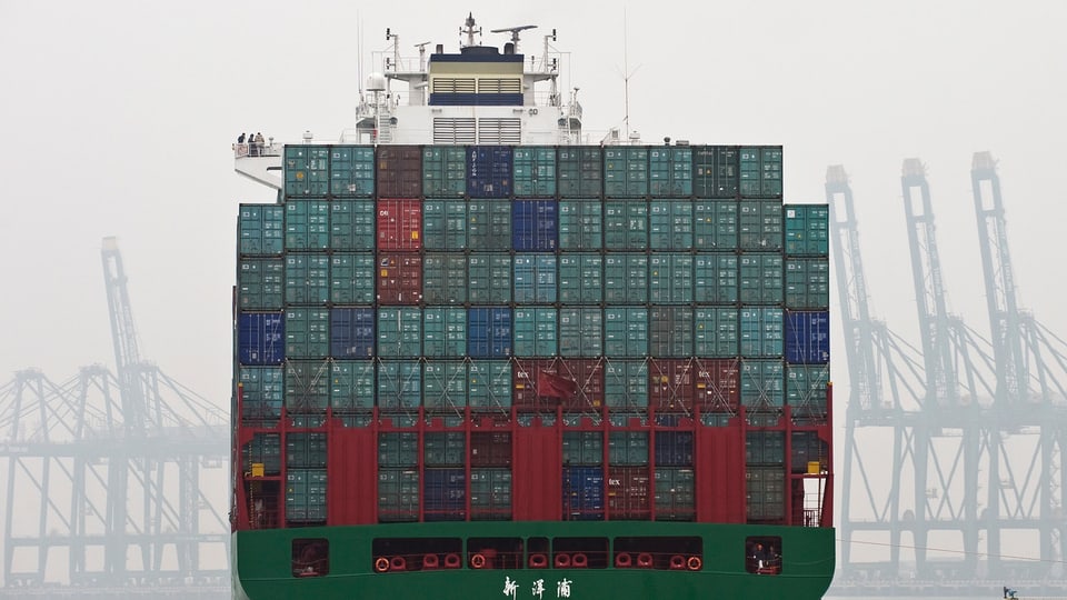 Ein Containerschiff verlässt den Tianjin Hafen in China.