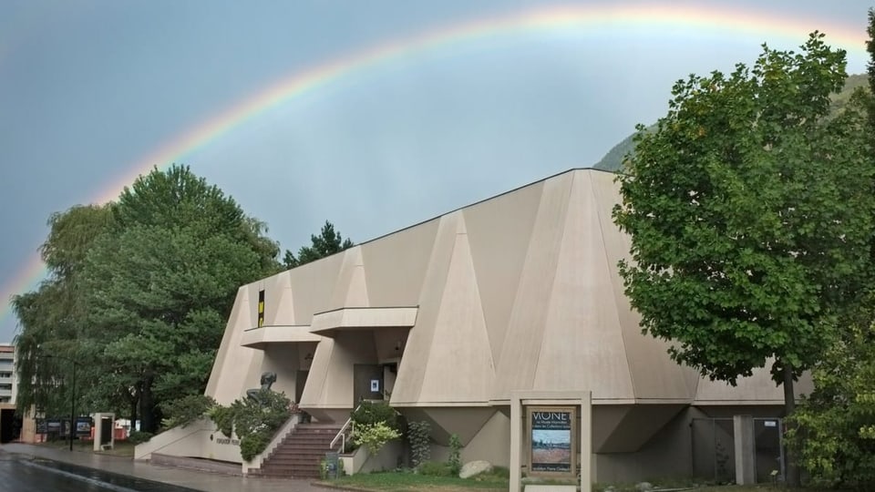 Ein Betongebäude unter einem Regenbogen. 