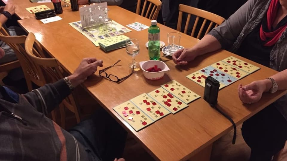 Mann und Frau sitzen an Tisch vor Lotto-Karten