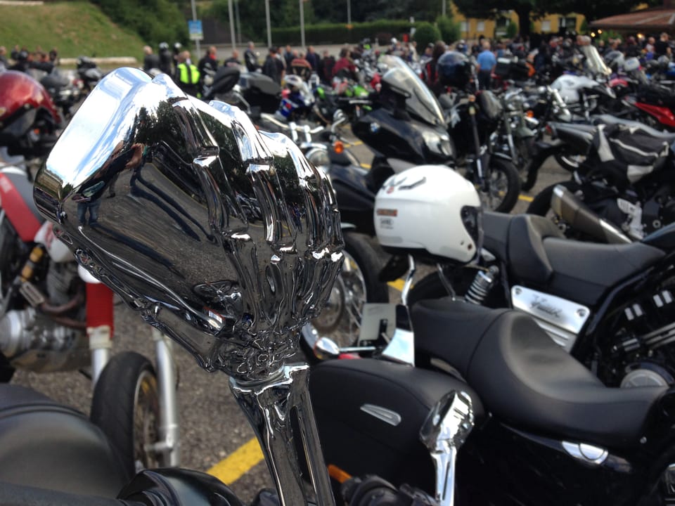 Viele Motorräder im Hintergrund, vorne eine Skeletthand aus Metall die den Rückspiegel hält.