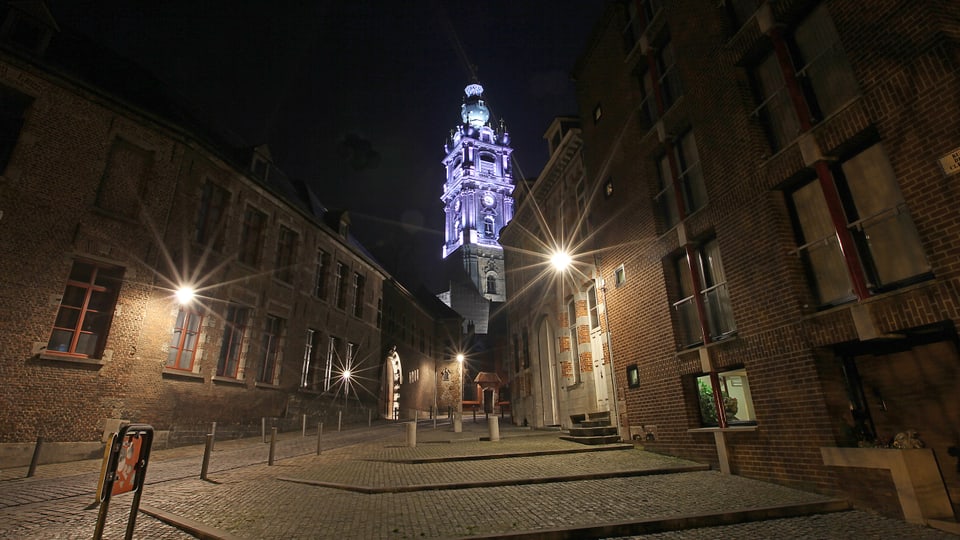 Blick in der Nacht auf einen blau beleuchteten Turm.