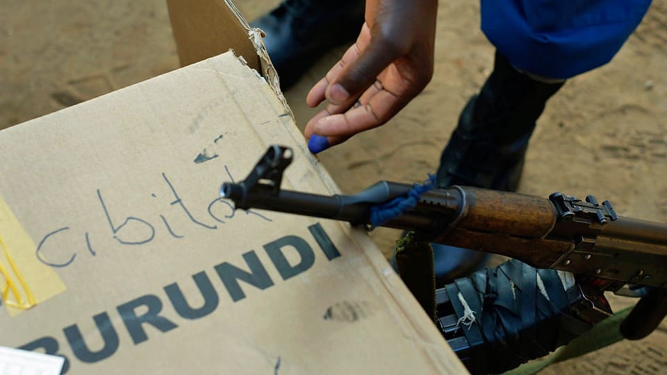Soldat mit Gewehr neben Wahlurne