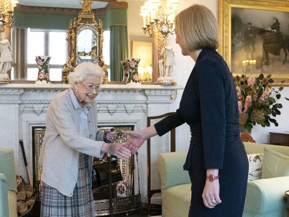 Die Queen und Liz Truss geben sich die Hand.