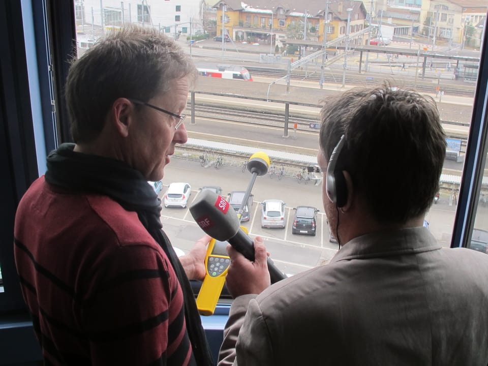 Markus Gugler und Maurice Velati stehen am offenen Fenster im Büro.