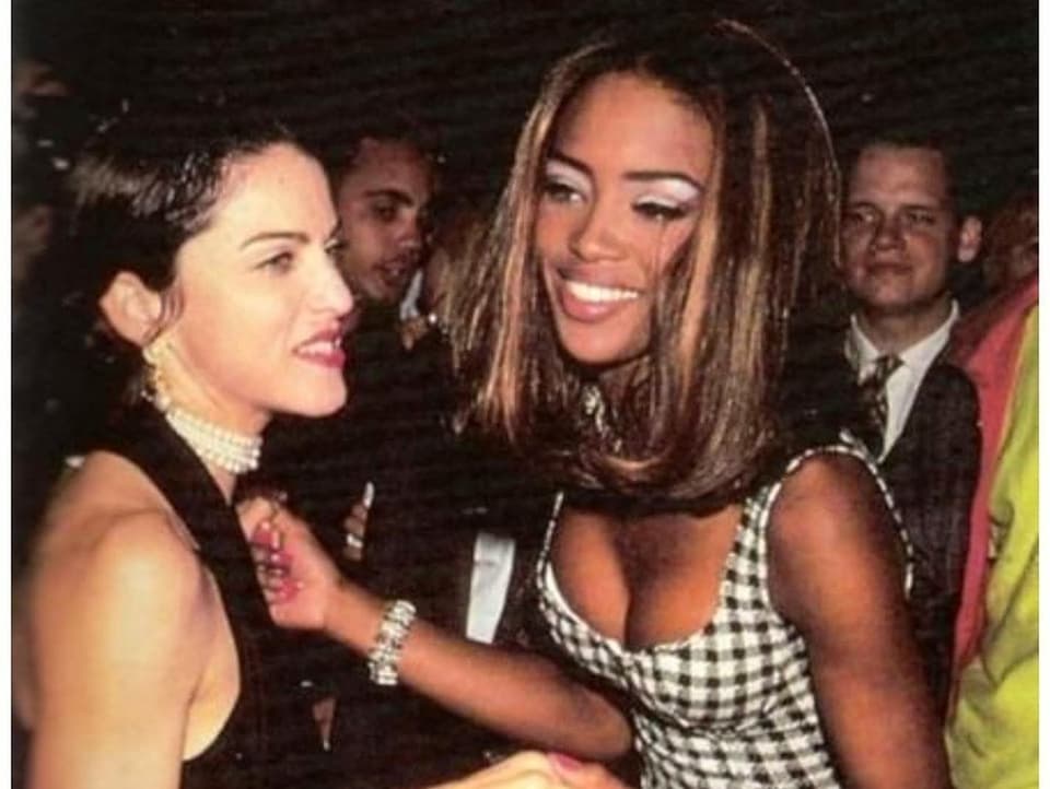Ein Bild von Madonna und Naomi Campbell. Es scheint in den 90er-Jahren an einer Party aufegnommen worden zu sein. Madonna trägt ein schwarzes Kleid und Naomi ein schwarz-weiss kariertes.