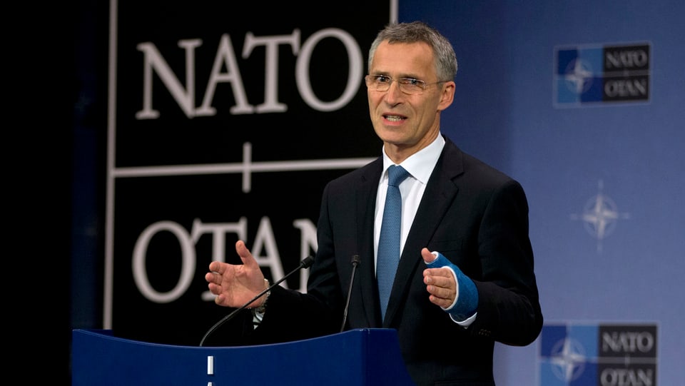 Stoltenberg spricht am Rednerpult vor dem weissen Nato-Logo auf schwarzem Grund.