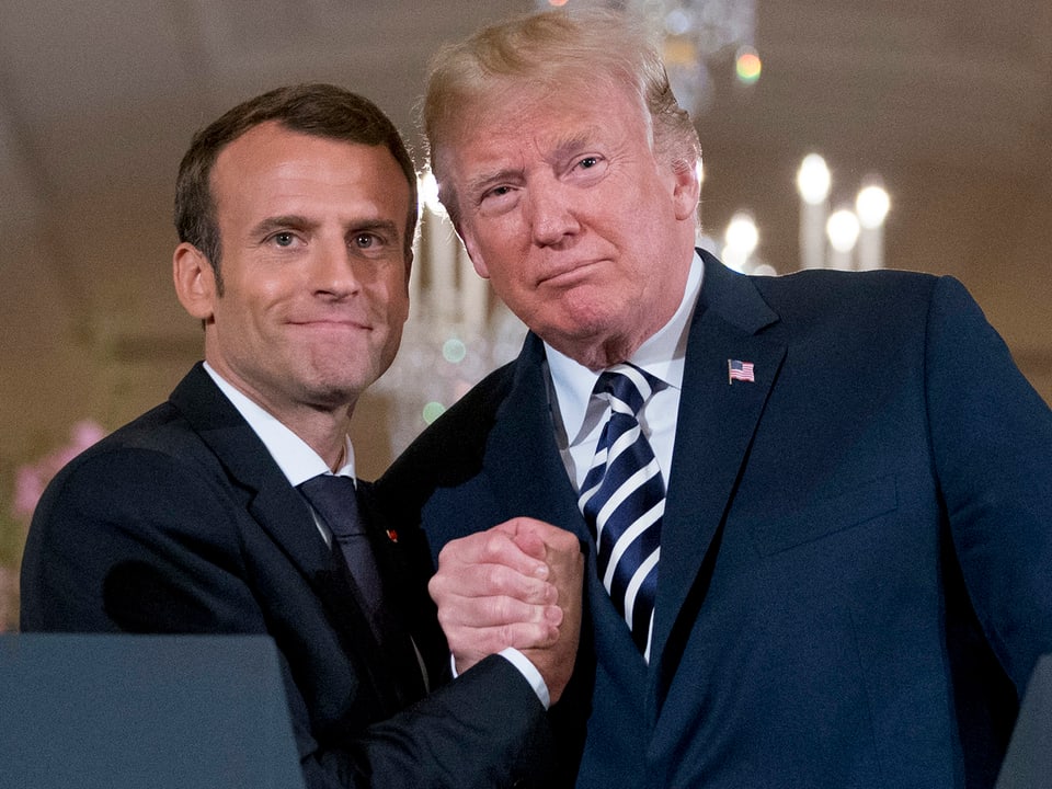 Macron gibt Trump die Hand.