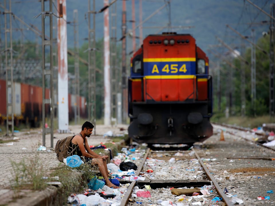Ein Mann sitzt alleine auf dem Perron des griechischen Bahnhofs Idomeni, an der Grenze zu Mazedonien