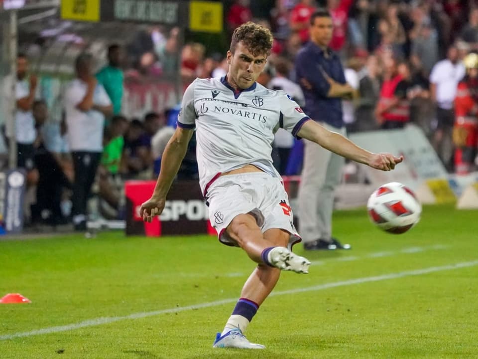Lopez vom FC Basel macht ein konzentriertes Gesicht, streckt leicht die Zunge raus und gibt den Ball ab.