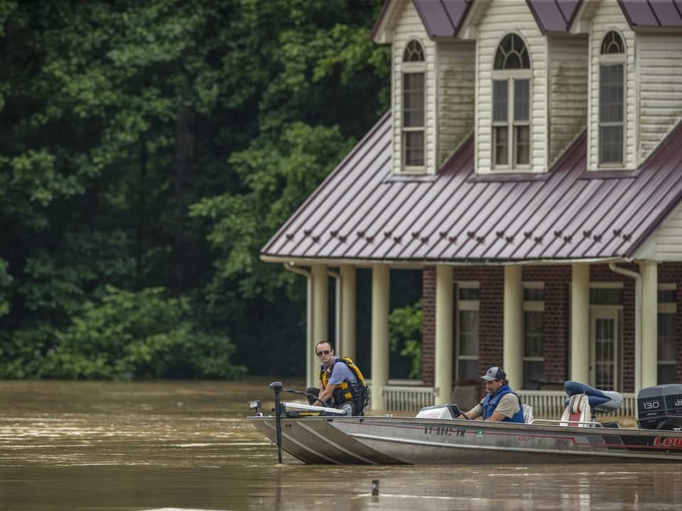 Menschen auf einem Boot im überschwemmten Kentucky.