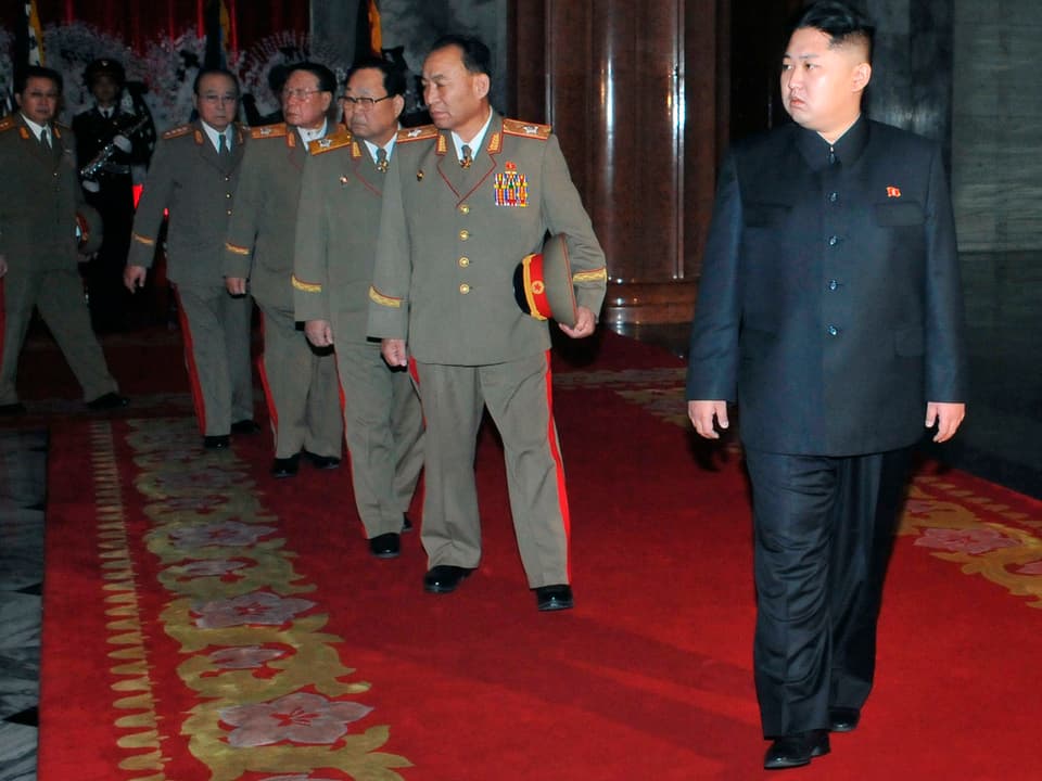 Kim Jong Un läuft vor ranghohen Militärangehörigen in einer Reihe.