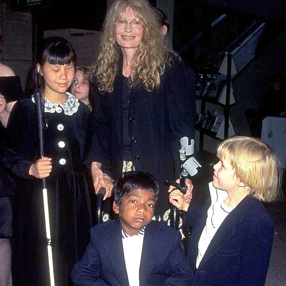 Mia Farrow mit drei ihrer Adoptivkinder. In der Mitte: Thaddeus.