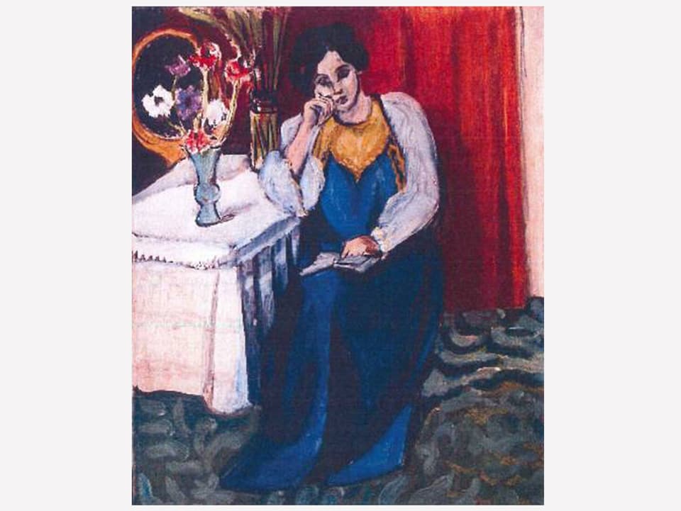 Frau in blauem Kleid am Tisch sitzend
