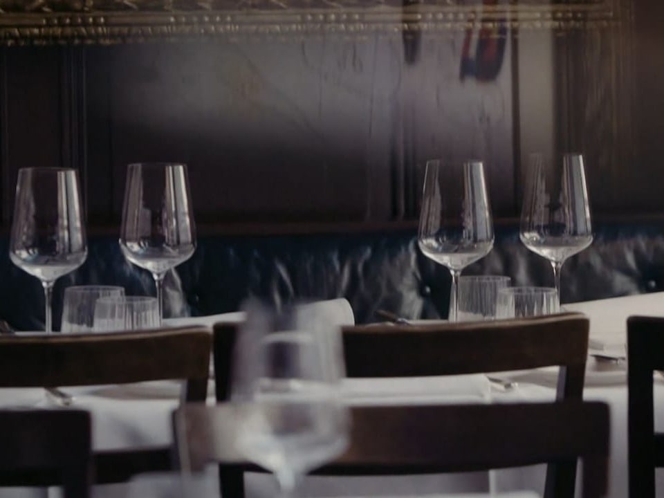 Elegant gedeckte Tische mit Weingläsern in einem Restaurant.