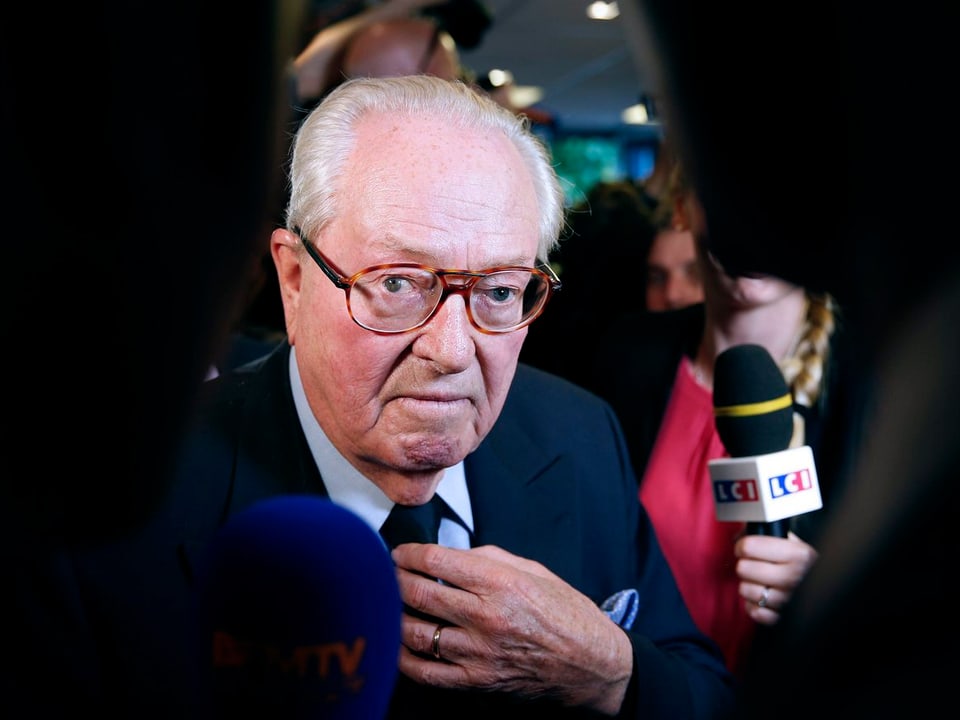 Jean-Marie Le Pen ist umringt von Mikrofonen