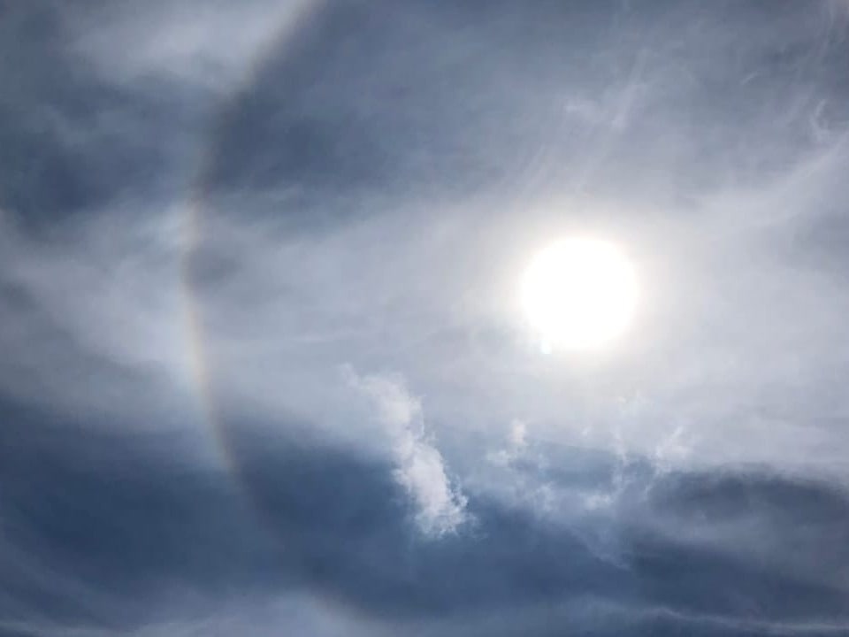 Regenbogen-Ring um die Sonne am milchigen Himmel