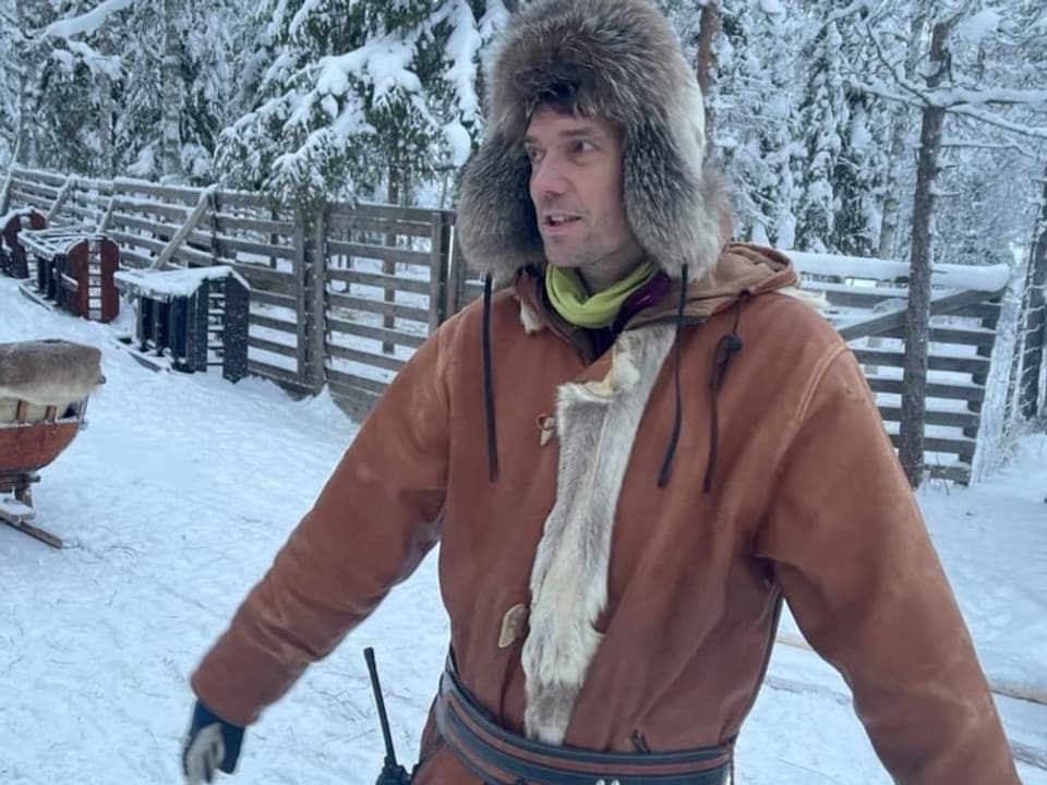 Ein Mann mit Pelzmütze im Schnee.