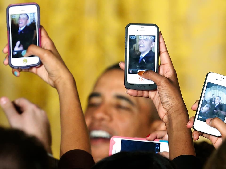 Obama wird von Menschen mit Smartphone gefilmt. 