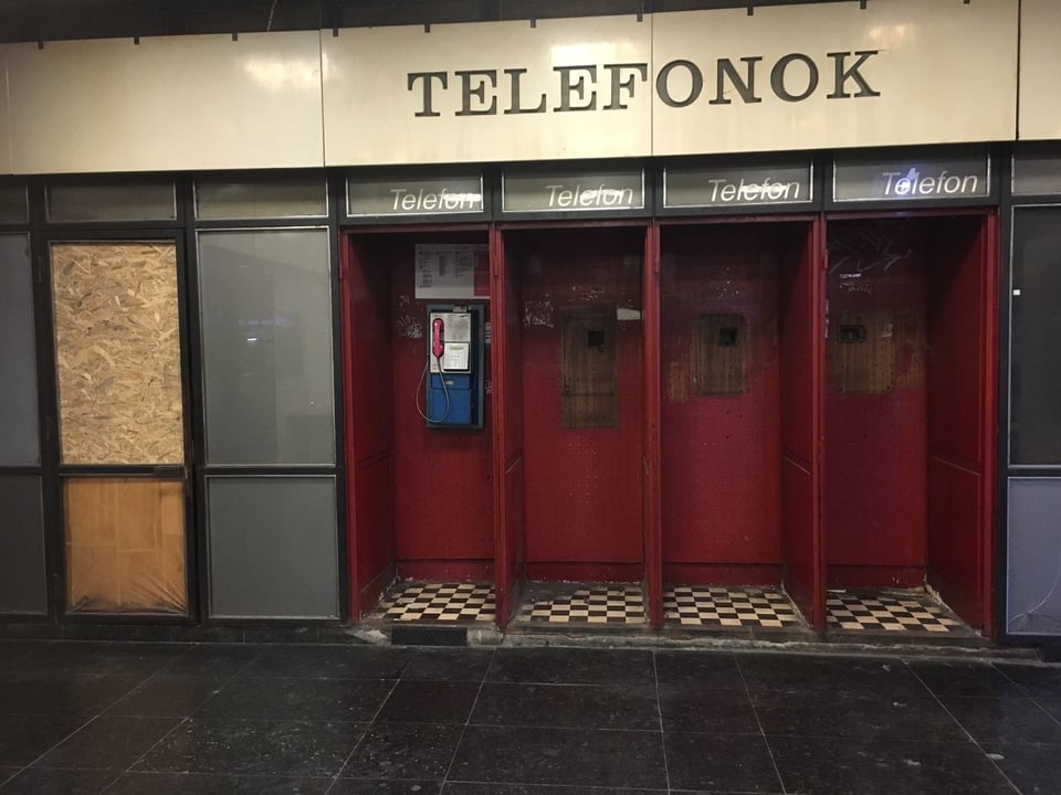 Vier nebeneinander stehende, teilweise bereits demontierte Telefonkabinen in Budapest.