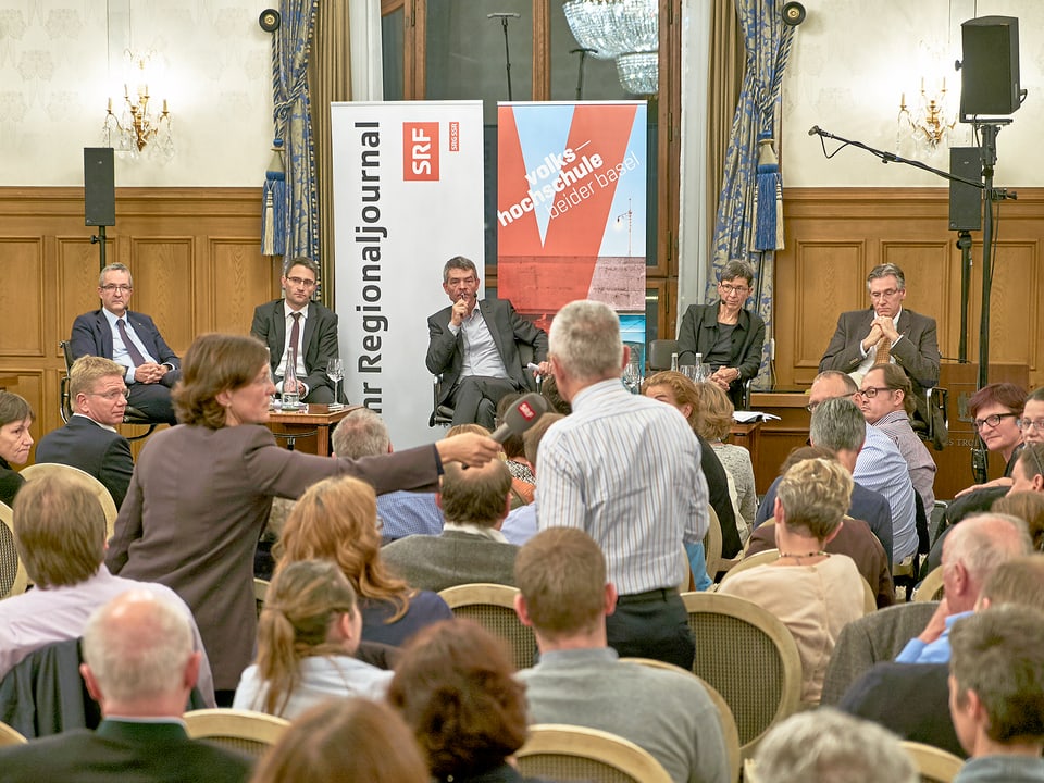 Ein Mann aus dem Publikum stellt eine Frage ans Podium