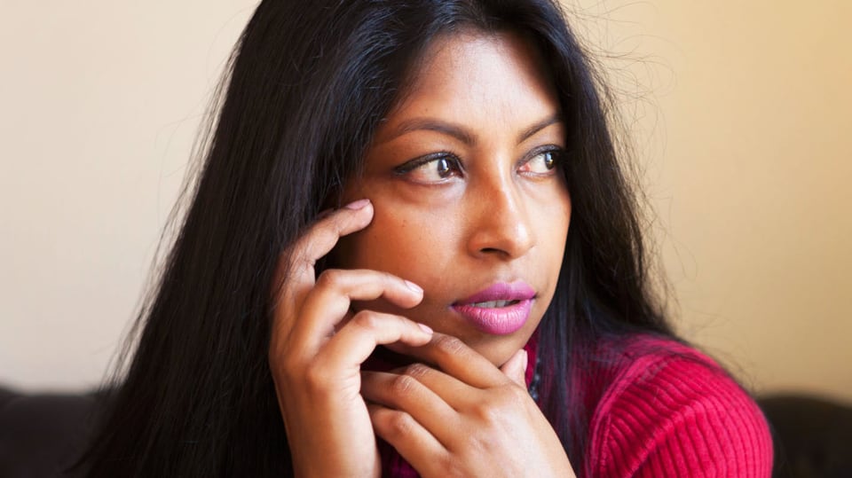 Shumona Sinha stützt ihren Kopf auf ihre Hände.