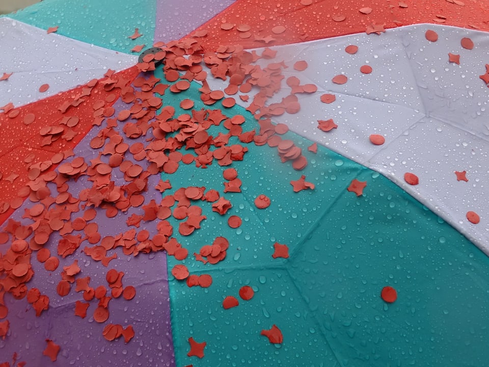 Bunter Regenschirm mit roten Räppli.