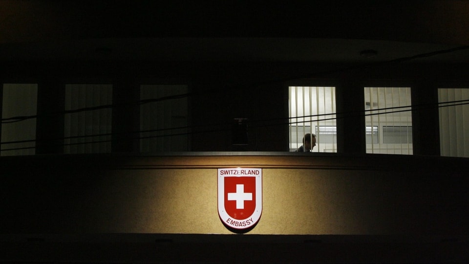 Gebäude mit Schild. Darauf das Schweizer Kreuz und die Aufschrift: Switzerland Embassy.