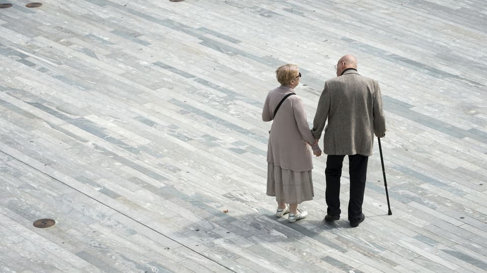 Ein Mann und eine Frau in hohem Alter stehen auf dem Sechseläutenplatz in Zürich.
