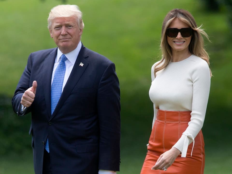 Donald Trump und seine Frau auf einer Wiese.