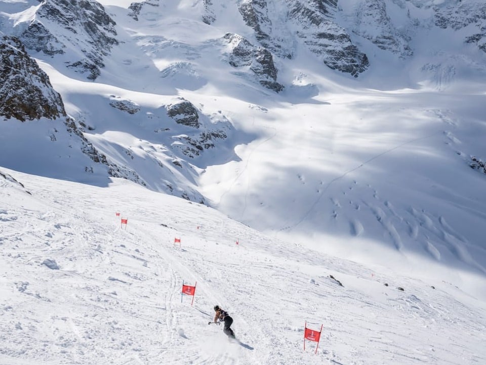 Nevin Galmarini auf der Gletscherabfahrt des «Diavolezza Glacier Race» mit Snowboard und einem Stock.