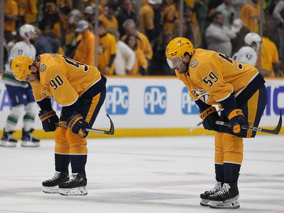 Zwei Eishockeyspieler in gelben Trikots auf dem Eis während eines Spiels