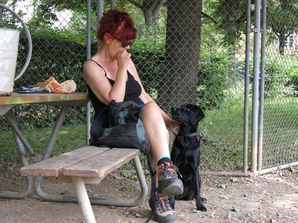 Frau mit Hund auf einer Bank