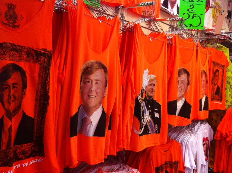 T-Shirts in Orange, nebeneinander hängend, mit dem Konterfei von Prinz Willem-Alexander