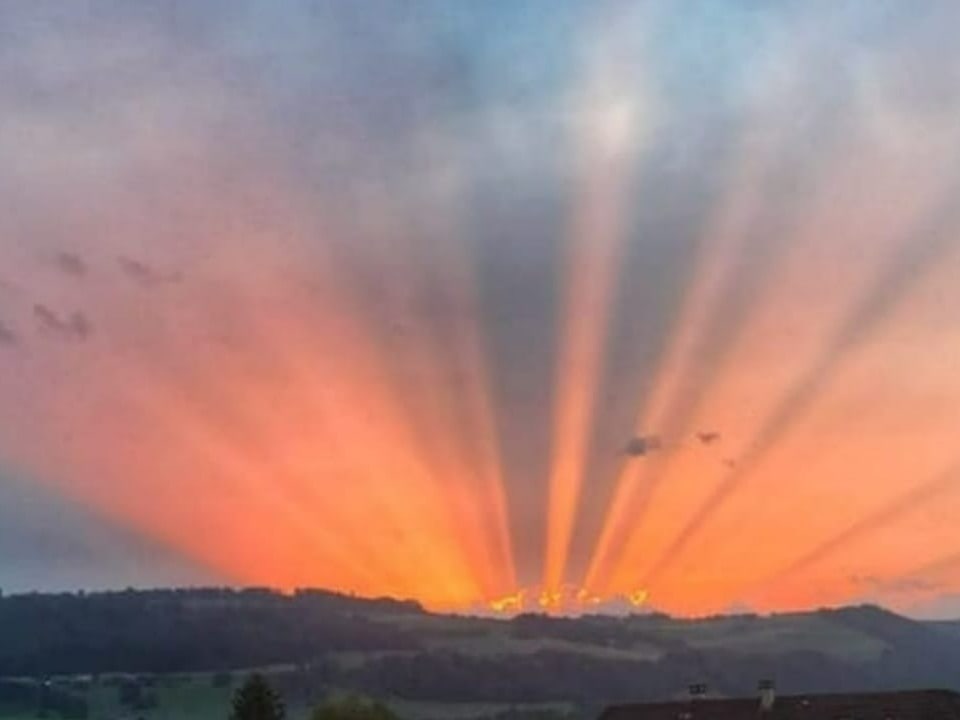 Strahlenbündel am Himmel der untergehenden Sonne.