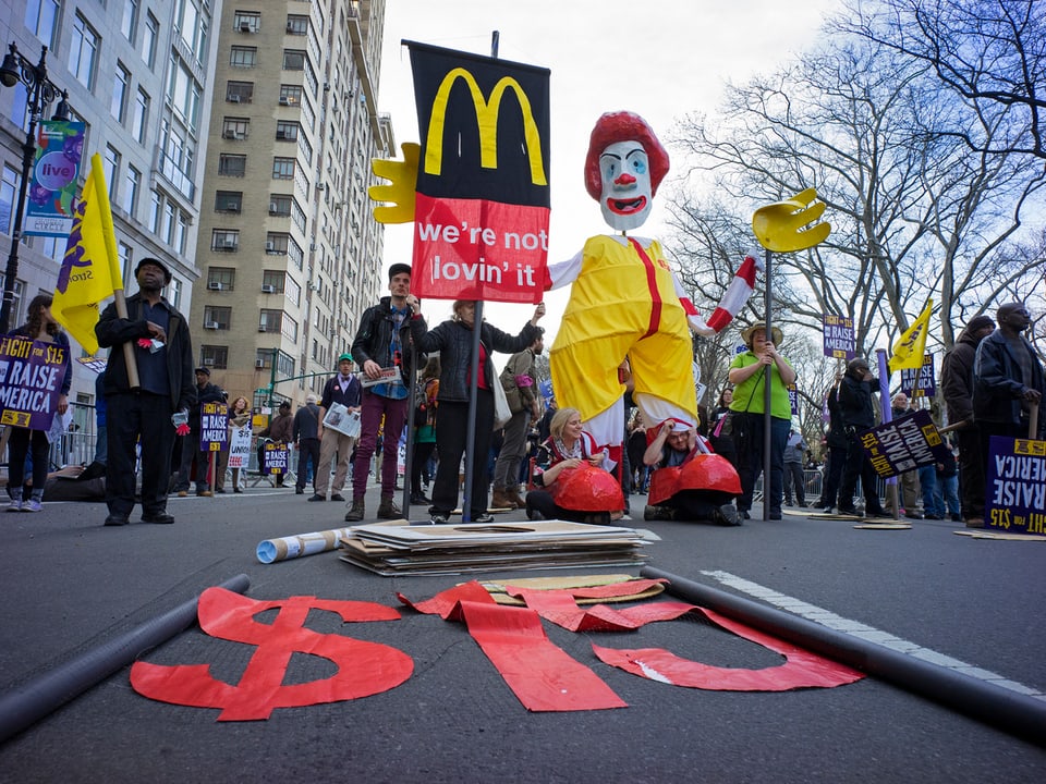 Demonstranten mit einer überlebensgrossen Ronald-McDonald-Figur