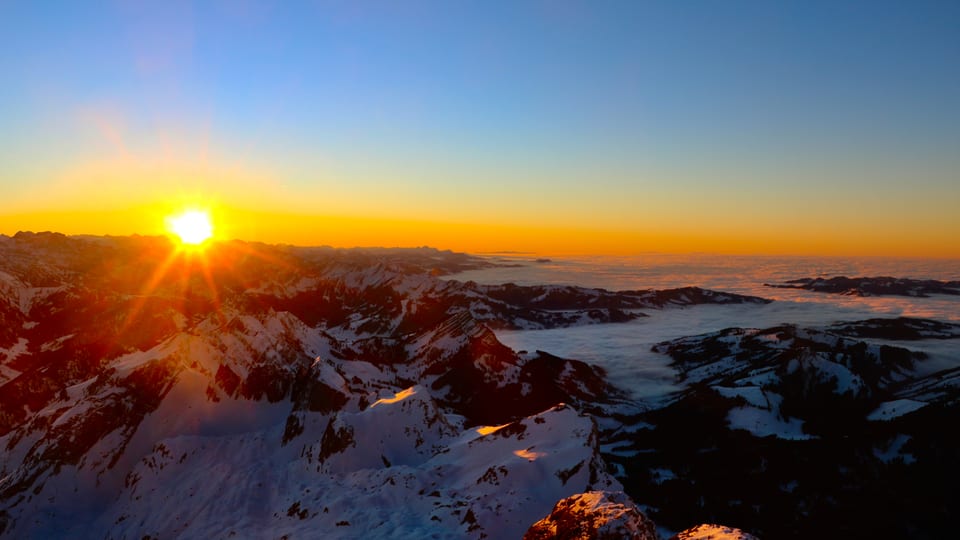 Blick vom Säntis auf den Sonnenuntergang, darunter die Berge der Zentralschweiz und ein Nebelmeer.