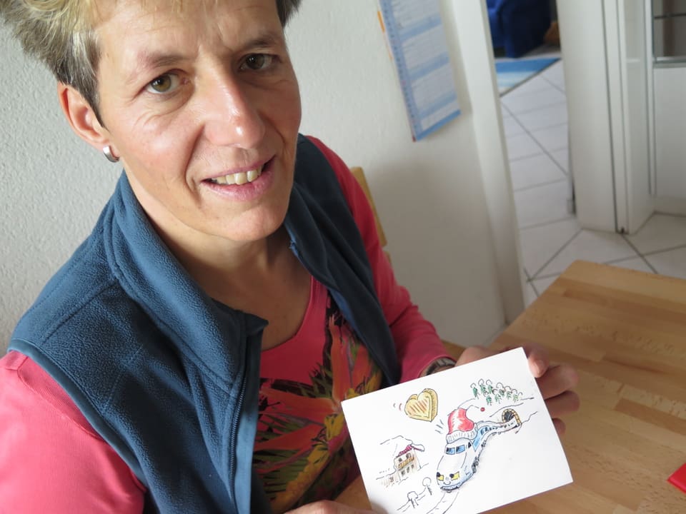 Sonja Schmid zeigt eine Gruss-Karte eines Lokomotivführers.  
