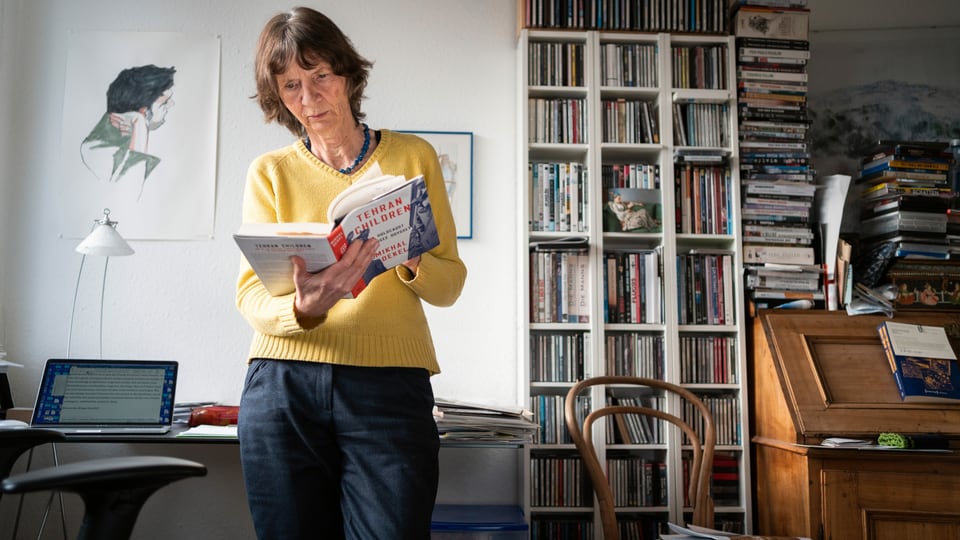Aleida Assmann in ihrem Büro, ein Buch in ihrer Hand.